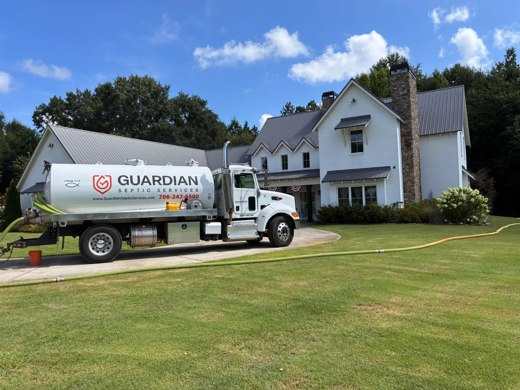 Guardian Septic Services vacuum truck pumping a septic tank at an Athens, Georgia home